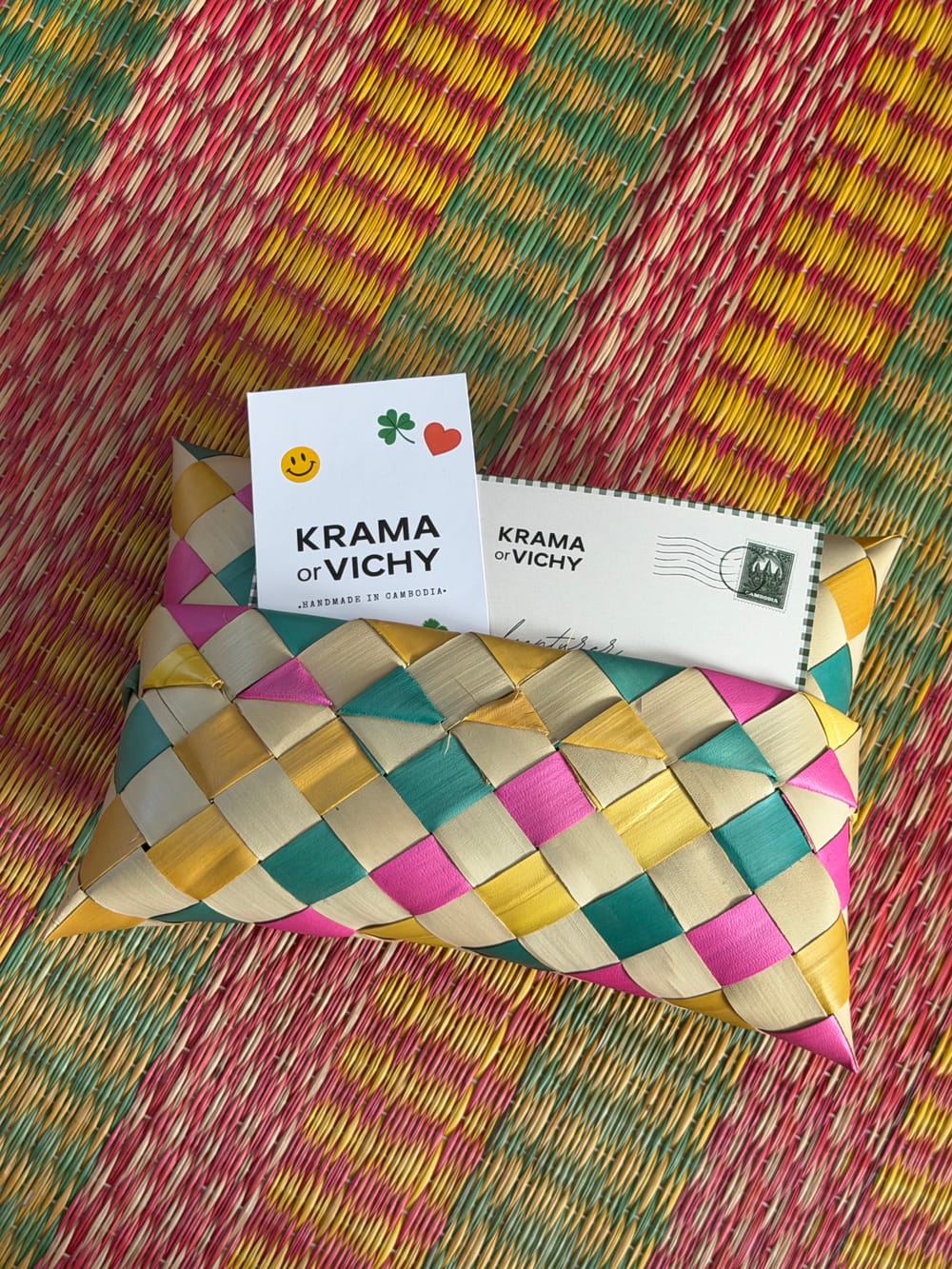 Une commande KRAMA or VICHY dans son emballage en feuille de palmier tressée, avec sa carte timbrée